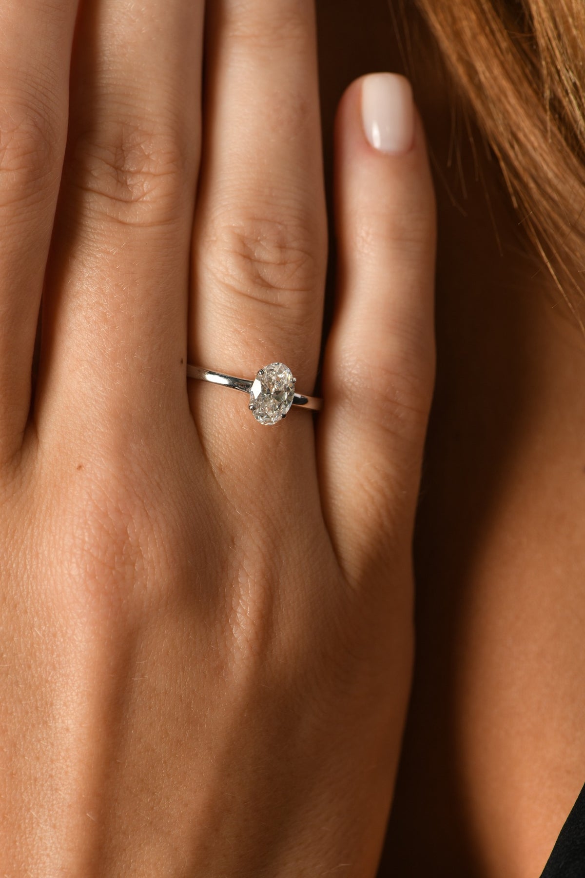 Oval diamond solitaire ring worn on hand